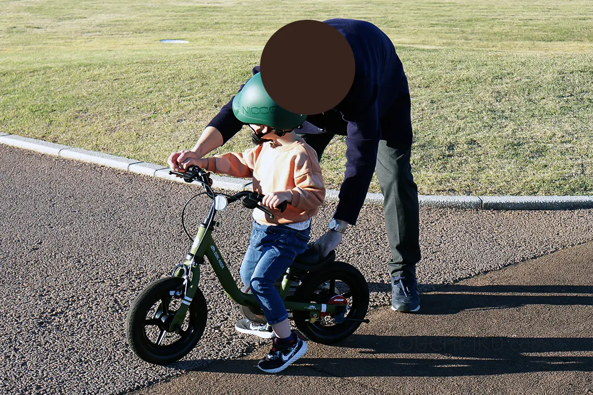 デュアルライダーのサポートハンドルを持ってもらいながら運転する３歳児