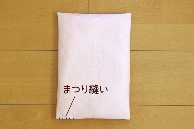 敷布団に綿を詰めて手でまつり縫いをする