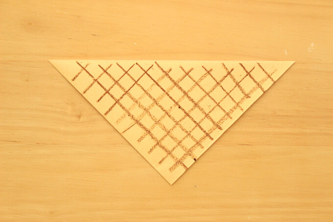 切った折り紙にコーンの凹凸模様を描く