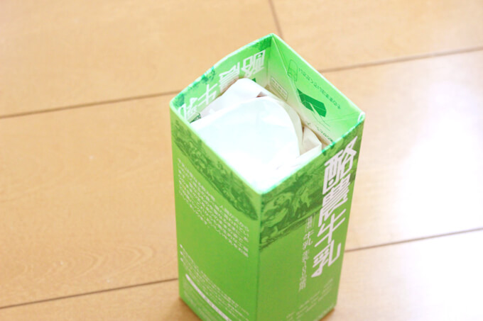 牛乳パックの中にチラシをつめる