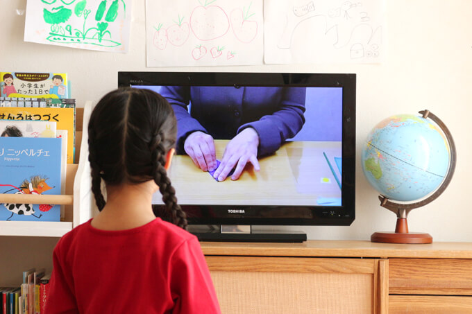 幼児教室の制作巧緻性問題キット「むすび」セットのビデオを見ているところ