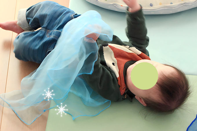 シフォンスカーフで遊ぶ赤ちゃん