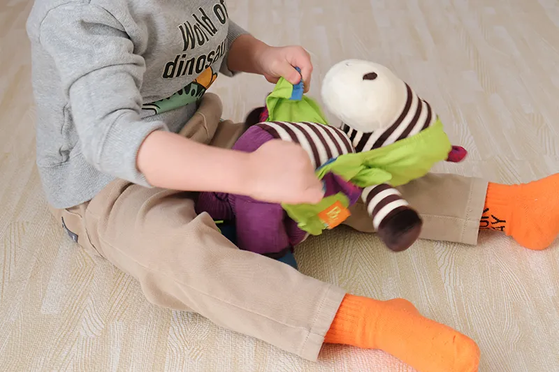 B.toys「おきがえしまうまくん」でジッパーの練習をする3歳児2