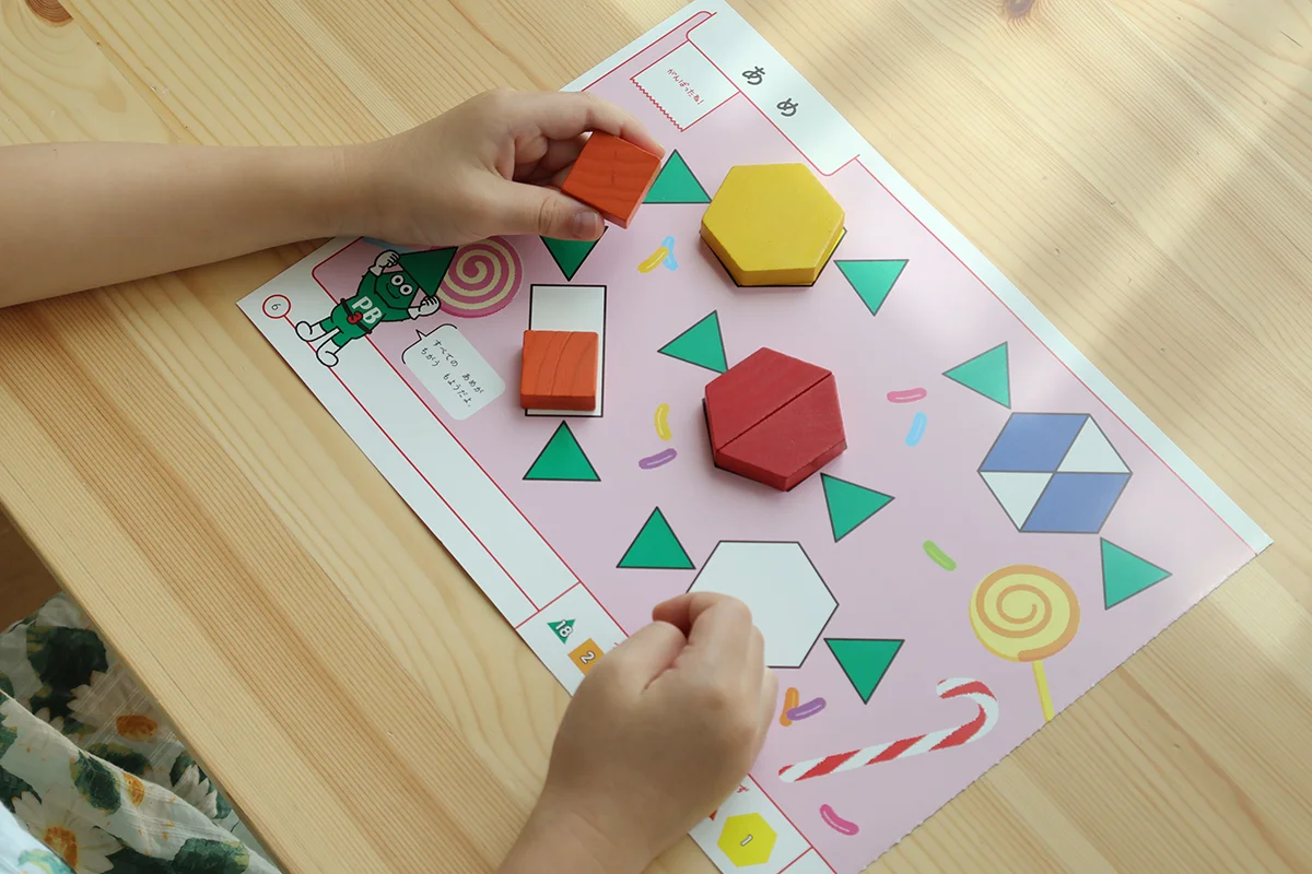 パターンブロックのタスクカードに取り組む2歳児