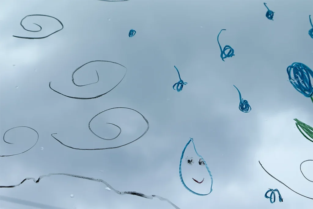 窓に描けるクレヨン・ペンで描いた雨粒の絵